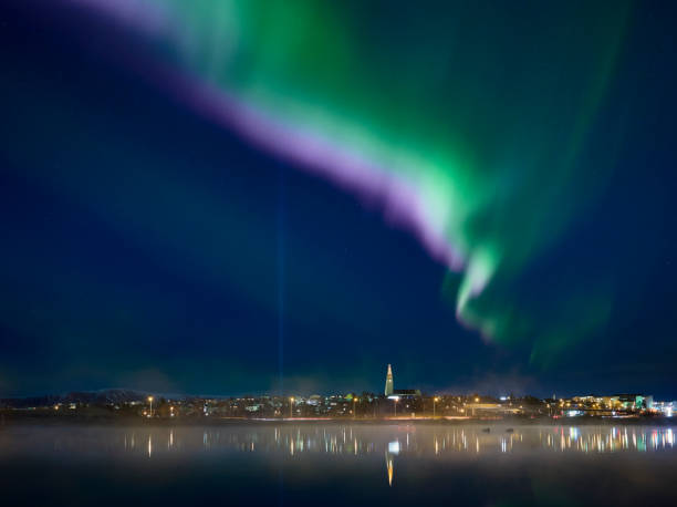 istock Coastal city against northern lights 1309107574