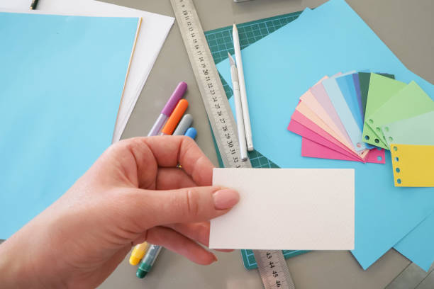 istock Female hands hold a white sheet. Free space for label placement. Samp 1309107700