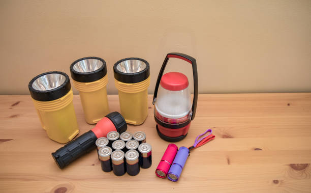 linternas y baterías dispuestas en una mesa preparada para un apagón. - hurricane lantern fotografías e imágenes de stock