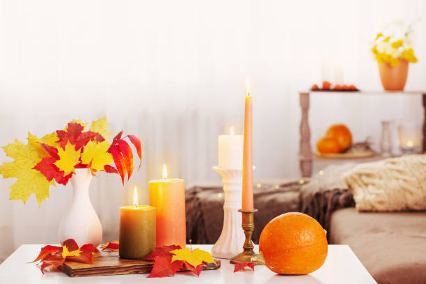 istock burning candles with autumn decor on white table at home 1309108785