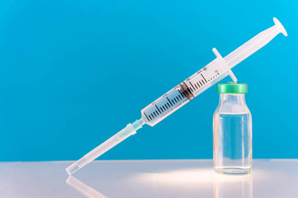istock Potential trials stage concept on blue background. Close up Vials with sterile needle syringe. Research and Development, Vaccination 1309111870