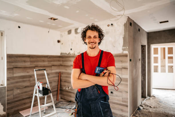 Smiling electrician renovating house Portrait of young handsome smiling electrician renovating house. Holding electrical measuring instrument. repairing electrical component stock pictures, royalty-free photos & images