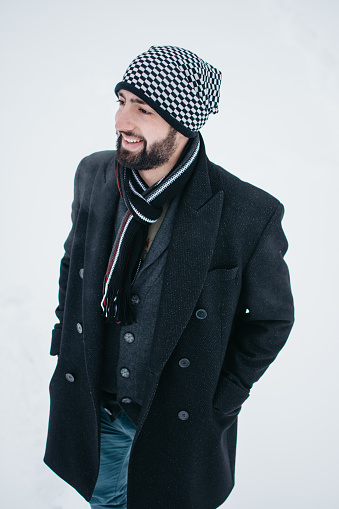 Portrait of a young man with a hat and scarf in a winter atmosphere