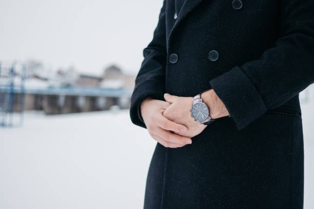 istock Man in a coat with a watch 1309114156