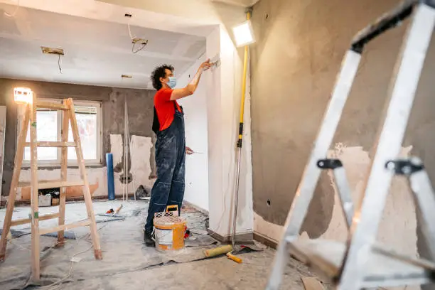 Photo of Construction worker plastering and smoothing concrete wall