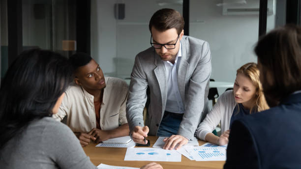 istock Skilled focused young leader analyzing sales data at brainstorming meeting. 1309116011