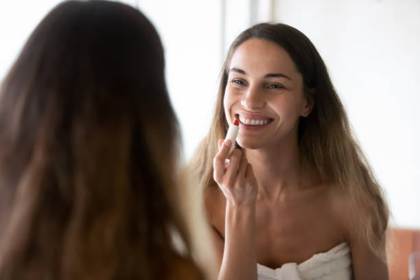 istock Smiling young female preparing to paint her lips in bathroom 1309116068