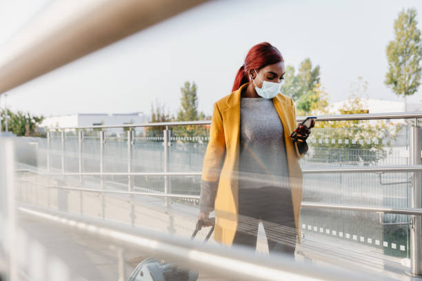 istock Woman at the train station waiting on platform 1309116240