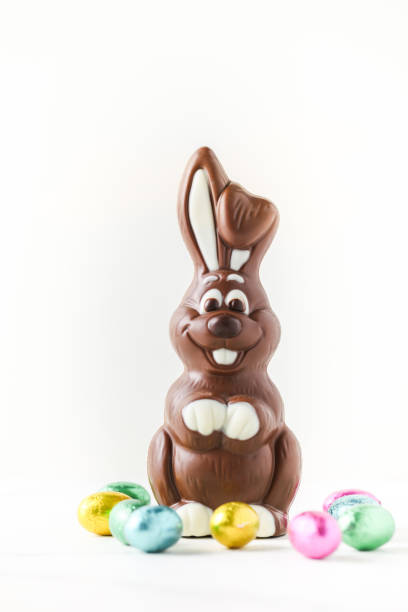 istock Chocolate Easter rabbit bunny surrounded by colorful eggs on the white background. 1309116848