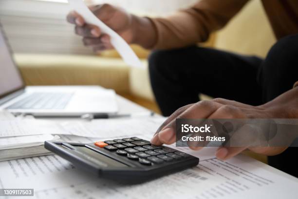 Close Up Of African American Man With Calculator Checking Bills Stock Photo - Download Image Now