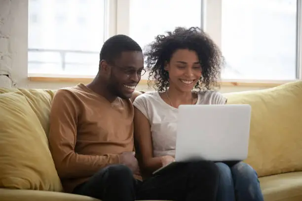 Photo of Happy black couple speak with friends online distance video call