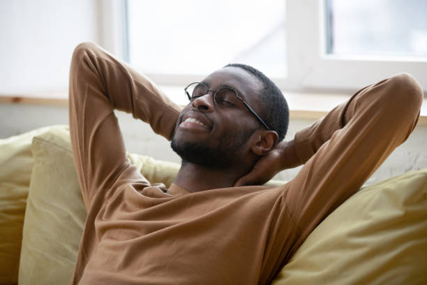istock Millennial african man resting on couch at home 1309117520