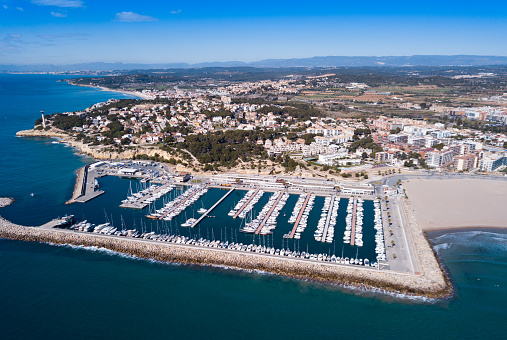 Picturesque aerial view of Mediterranean coastal town of Torredembarra with yachts moored in harbor, Tarragona, Spain