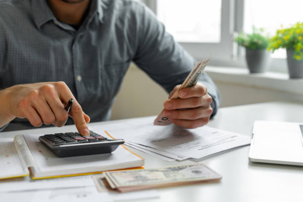 mens die calculator met behulp van - huishoudkosten stockfoto's en -beelden