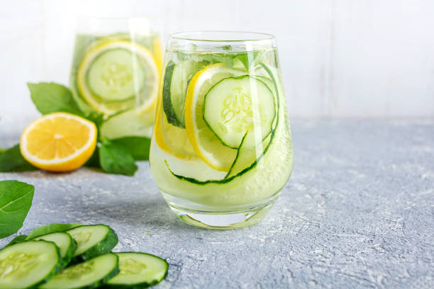 bebida fresca y fresca de agua de desintoxicación con pepino y limón. dos vasos de limonada con albahaca y hojas de menta. concepto de nutrición adecuada y alimentación saludable. dieta de fitness. copiar espacio para texto - pepino fotografías e imágenes de stock