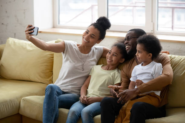 istock African American parent with two kids taking selfie. 1309119357