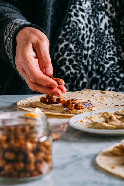 istock Woman is Preparing a Vegan Wrap With Chickpeas 1309119571