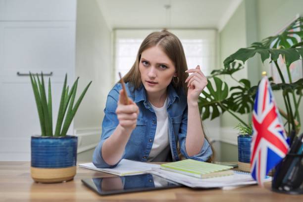 istock UK learning English online. Female student remotely looking at webcam 1309121007