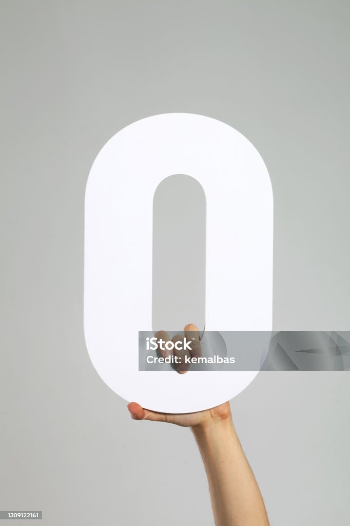 Letter O Or Zero A hand holding the letter O or zero. Zero Stock Photo
