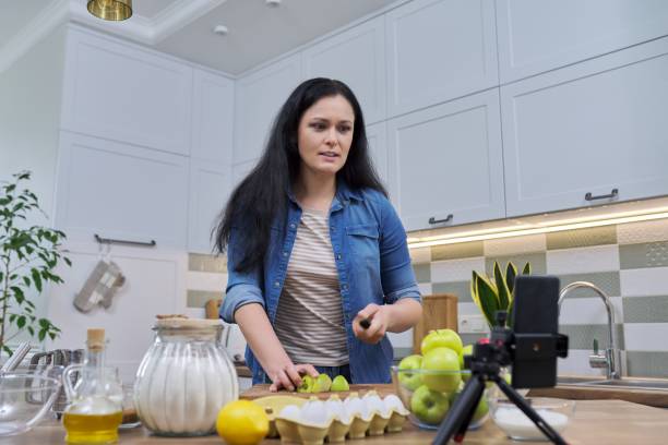 istock Woman cooking at home in kitchen, talking online using video call on smartphone 1309122214