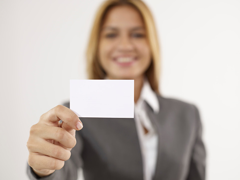 Businesswoman showing and holding a blank business card.