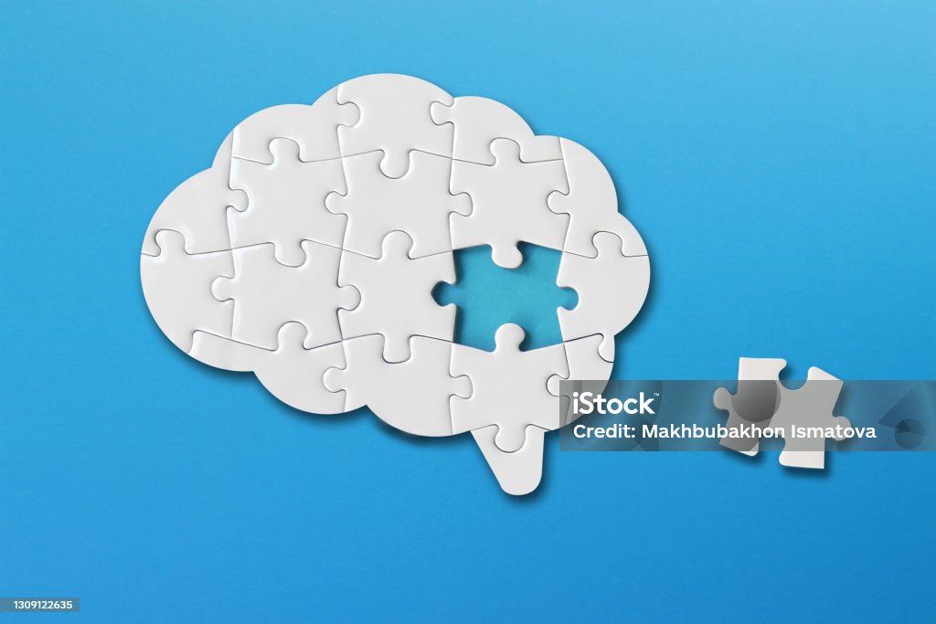 Brain shaped white jigsaw puzzle on blue background, a missing piece of the brain puzzle, mental health and problems with memory Puzzle Stock Photo