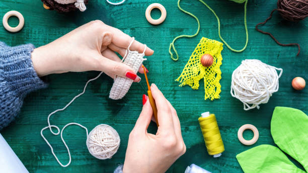 istock Woman is knitting using hooks and white yarn 1309123901