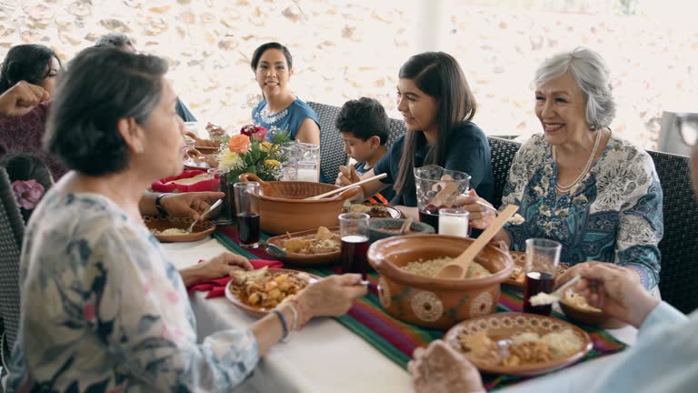 Mexican multi generation family eating together outdoors