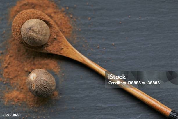 Nutmeg Spicewhole And Ground Nutmeg In A Wooden Spoon Closeup On A Black Schiffer Backgroundspices And Herbs Conceptfood Spices For Meat And Bakingnutmeg Powder Stock Photo - Download Image Now