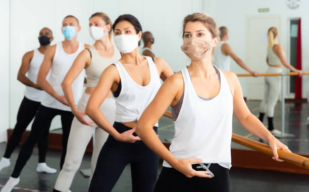 istock People in masks doing exercises using  barre in  gym 1309124070