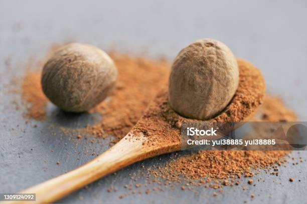 Nutmeg Spicewhole And Ground Nutmeg In A Wooden Spoon Closeup On A Black Schiffer Backgroundspices And Herbsfood Ingredientspices For Meat And Bakingnutmeg Powder Stock Photo - Download Image Now