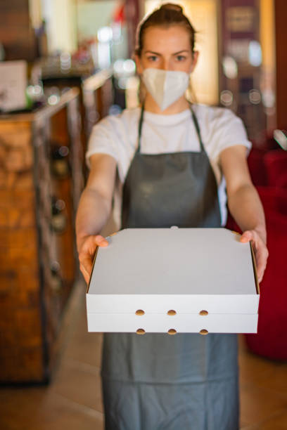 istock Waitress holding pizza boxes at restaurant 1309125097