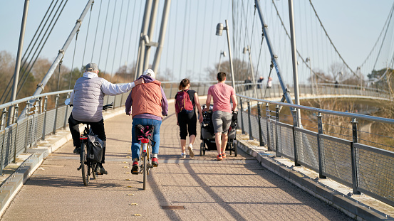 Magdeburg, Germany – February 25, 2021: Bicyclists and walkers on the Herrenkrugsteg suspension bridge on their way across the Elbe to Herrenkrugpark in Magdeburg