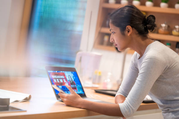istock Young woman watching news broadcasting on laptop screen 1309127764