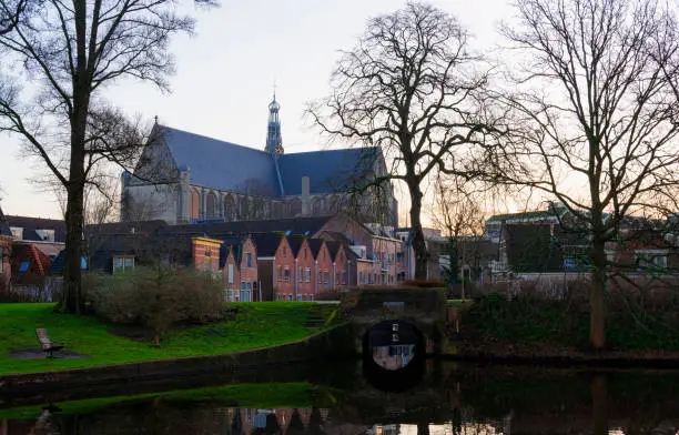 The big Saint-Laurens church in the historic city centre of Alkmaar, the Netherlands, with a canal, Singel, in the foreground. The small bridge is also a sluice.