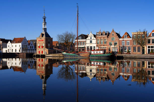 The Accijnstoren, excise tax tower, in Alkmaar, Netherlands, along a canal and 16th century houses
