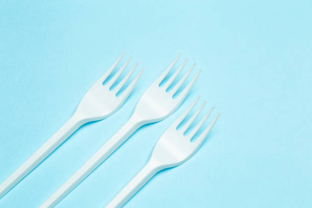 istock Plastic forks on a blue background. Plastic waste and pollution concept 1309129157