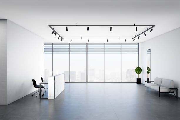 istock White office lobby with a blank white wall in the background, concrete floor and a window. 1309130382