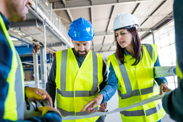 istock Architect talking with team at an indoor construction site 1309130633