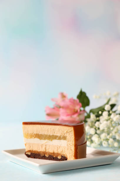 Beautiful cut of a piece of mousse cake on a plate with flowers