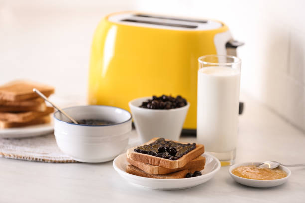 istock Modern toaster and delicious breakfast on table in kitchen 1309135854