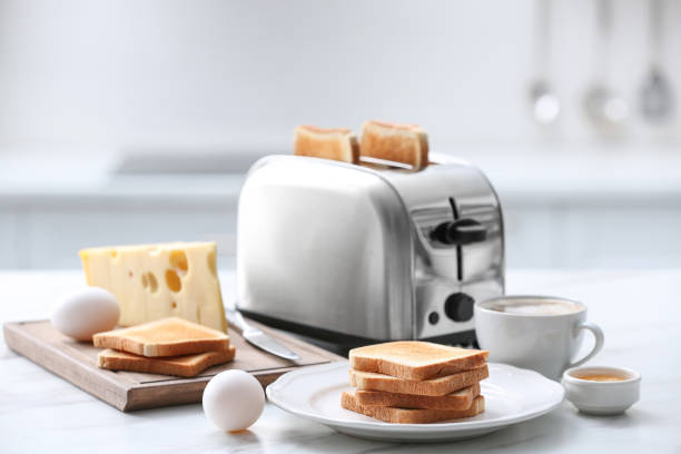 istock Modern toaster and tasty breakfast on white marble table in kitchen 1309135865