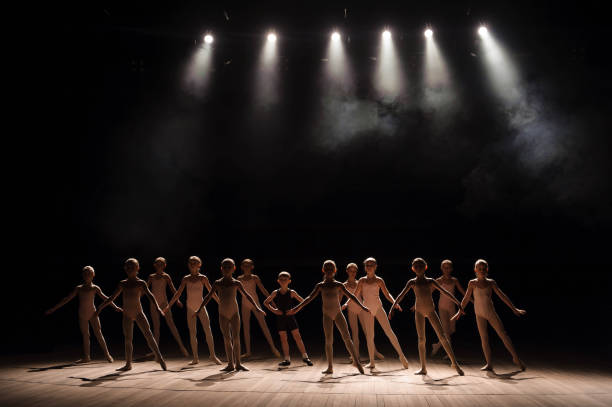 istock Young ballerinas rehearsing in the ballet class. They perform different choreographic exercises and stand in different positions. 1309136502