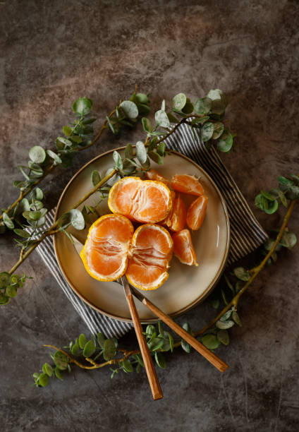 istock Tangerine slices on a gray plate on a gray-black stone background 1309136607