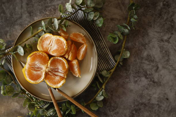 istock Tangerine slices on a gray plate on a gray-black stone background 1309136736