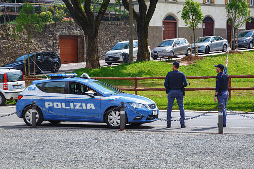 BERGAMO, ITALY - MAY 22, 2019: Police officers stop passing cars with a stop signal to check documents.
