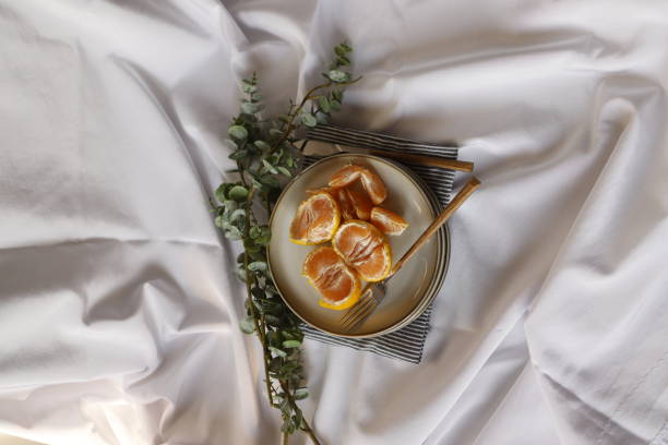 istock Tangerine slices on a gray plate on a white tablecloth 1309136845