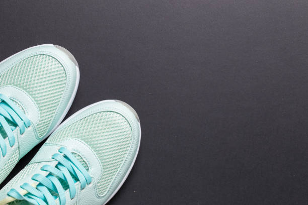 istock Turquoise sneakers and turquoise dumbbells with a white sole on a black background 1309138367