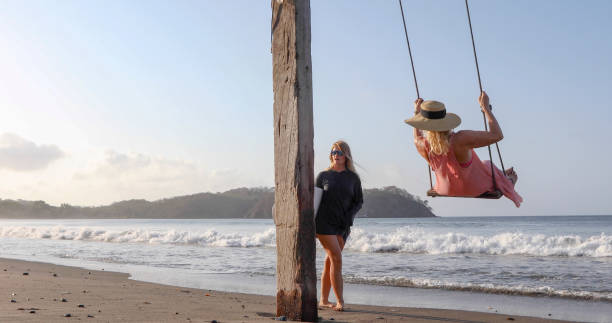 istock Women exchange greetings on sandy beach 1309139610