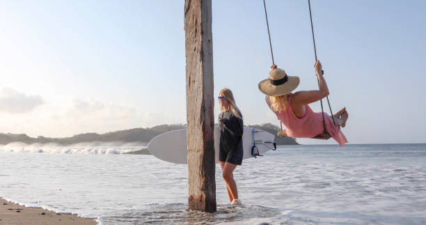 istock Women exchange greetings on sandy beach 1309139615